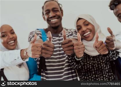 Group portrait of happy African students standing together against a white background and showing ok sign thumbs up girls wearing traditional Sudan Muslim hijab fashion. High-quality photo. Group portrait of happy African students standing together against a white background and showing ok sign thumbs up girls wearing traditional Sudan Muslim hijab fashion
