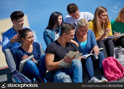 Group portrait of happy students outside in front of school sitting on steps have fun