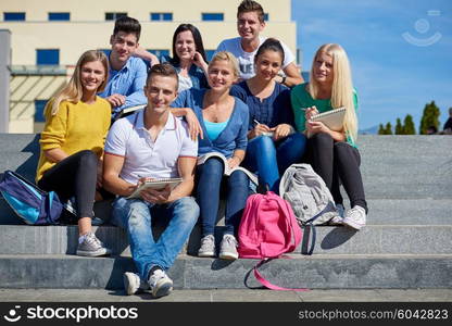 Group portrait of happy students outside in front of school sitting on steps have fun