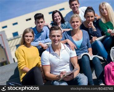 Group portrait of happy students outside sitting on steps have fun