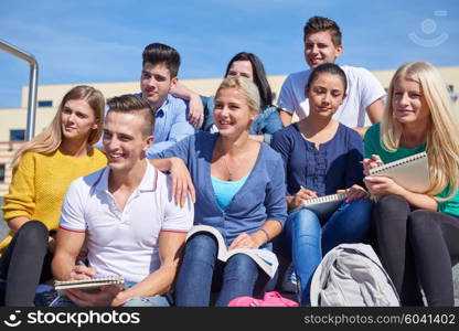 Group portrait of happy students outside sitting on steps have fun