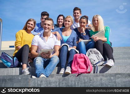 Group portrait of happy students outside sitting on steps have fun