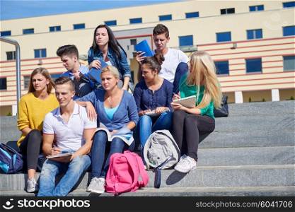 Group portrait of happy students outside sitting on steps have fun