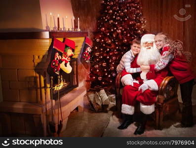 Group portrait of Kind Santa Claus sitting with Happy Children