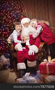 Group portrait of Kind Santa Claus sitting with Happy Children