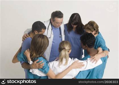 Group portrait of nurses and doctors in huddle