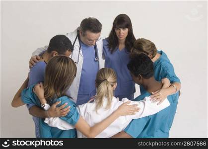 Group portrait of nurses and doctors in huddle