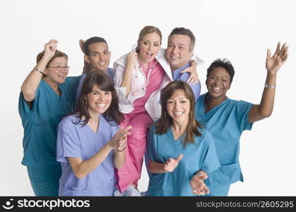 Group portrait of nurses carrying doctor