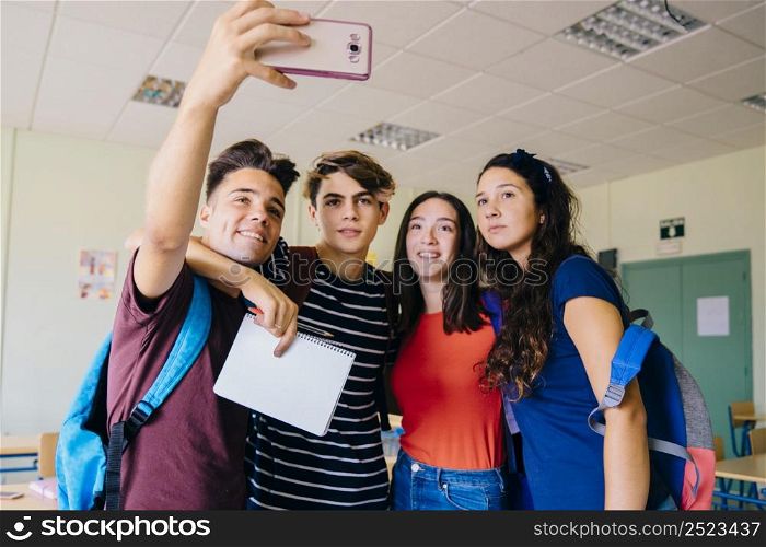 group schoolkids taking selfie classroom