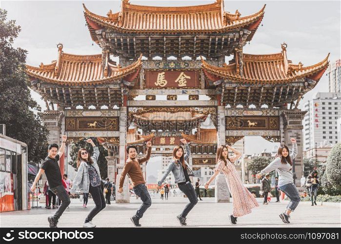 Group shot action of asian friendship over the Kunming Jinbi square, Kunming, China, travel and tourism with friend ship, dancing and parody cover concept,Chinese Text is Golden Horse and Jade Rooster