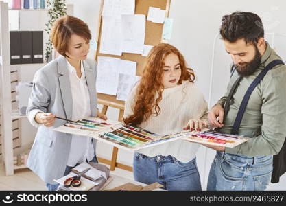 group three fashion designers working atelier with color palette