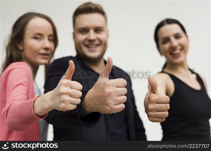 group young people showing thumbs up gesture