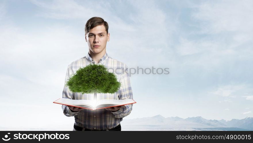 Grow your knowledge. Young man with book in hands and green tree on pages