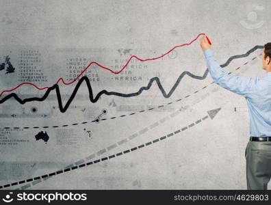 Growing graph. Back view of businessman drawing graphs on wall