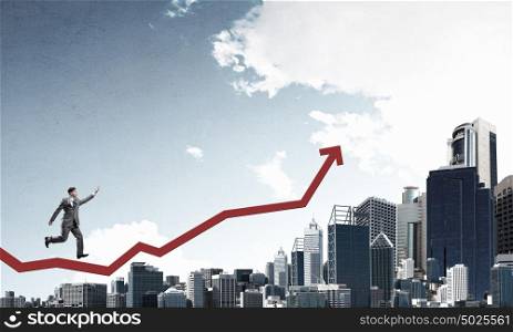 Growth and progress in business. Young businessman running on increasing arrow graph