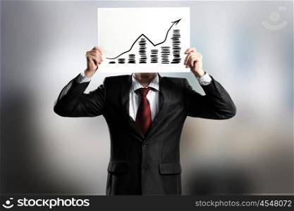 Growth concept. Businessman hiding his face behind paper with drawing