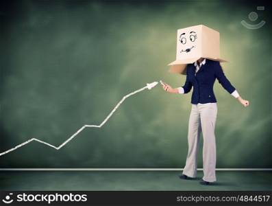 Growth concept. Businesswoman wearing carton box with smiley on head
