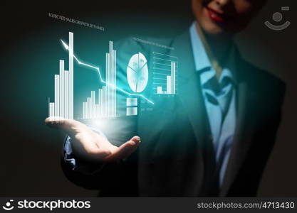 Growth concept. Close up of businesswoman holding graphs in hand