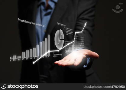 Growth concept. Close up of businesswoman holding graphs in hand