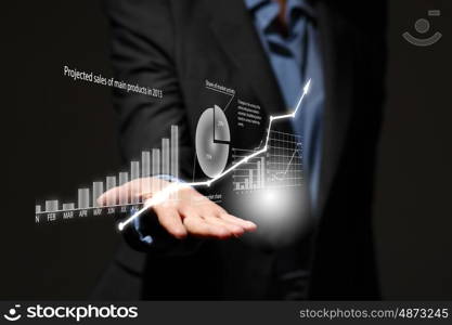 Growth concept. Close up of businesswoman holding graphs in hand