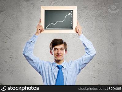 Growth concept. Handsome businessman holding frame with graph drawing