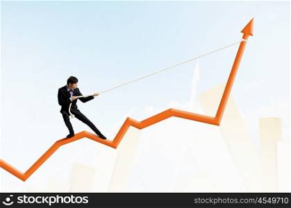Growth concept. Image of businessman standing on graph and pulling it upwards