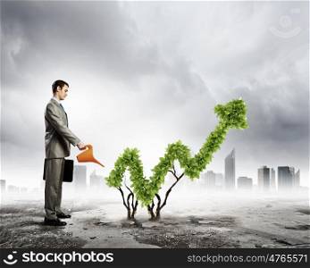 Growth concept. Image of businessman watering plant shaped like arrow
