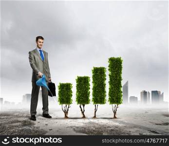 Growth concept. Image of businessman watering plant shaped like graph