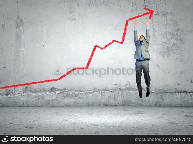 Growth concept. Image of young businessman jumping above graph
