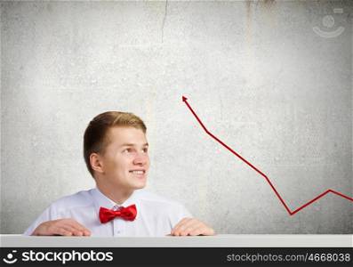Growth concept. Young businessman looking at red increasing graph