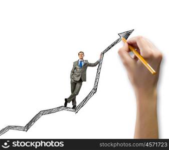 Growth concept. Young businessman standing on drawn graph arrow