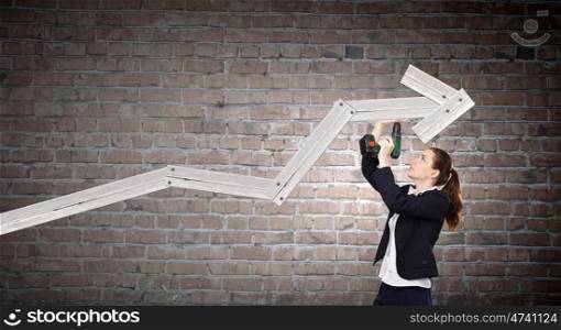 Growth concept. Young businesswoman fixing increasing arrow with drill