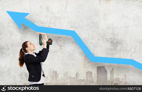 Growth concept. Young businesswoman fixing increasing arrow with drill