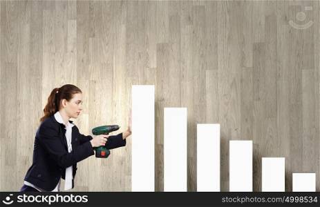 Growth concept. Young businesswoman fixing increasing arrow with drill