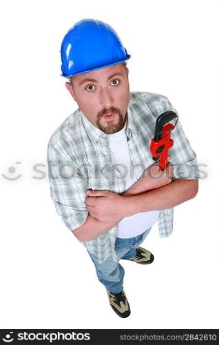 Grumpy plumber posing with wrench