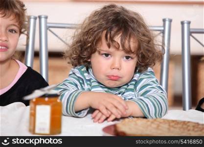 Grumpy toddler waiting to eat pancakes