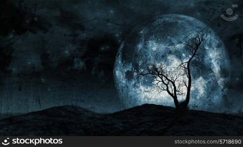 Grunge background of a spooky silhouette of a tree against a large moon in a night sky