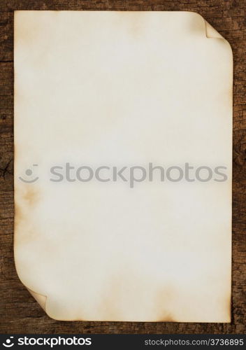 Grunge background with a burned piece of paper on the board