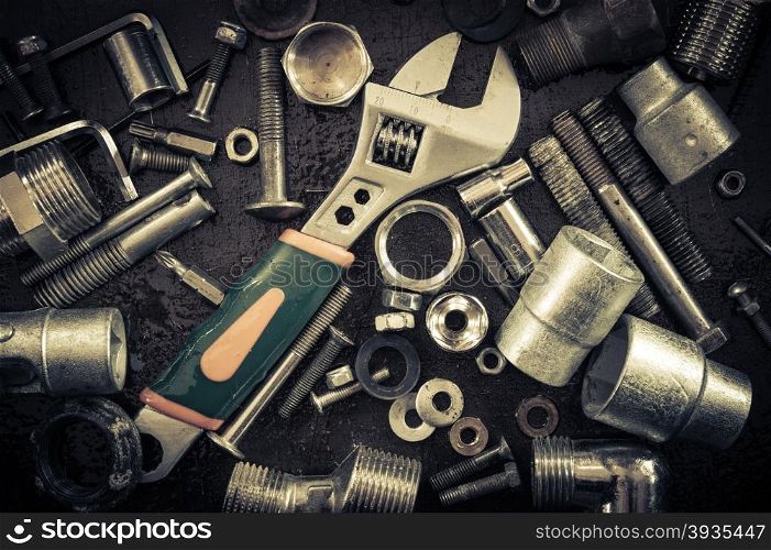 Grunge background with tools and bolts. Adjustable wrench, screws, nuts. Toned.