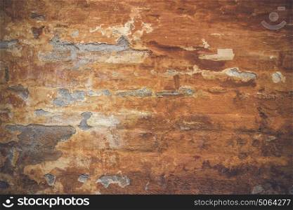 Grunge old wall with orange paint peeling off the weathered brick wall