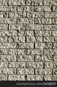 Grunge style brick wall with rough bricks in sunlight