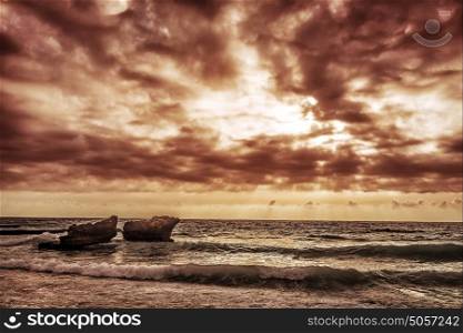 Grunge style photo of cliffs in Mediterranean sea in Lebanon, dark cloudy sky, overcast weather, summer storm concept