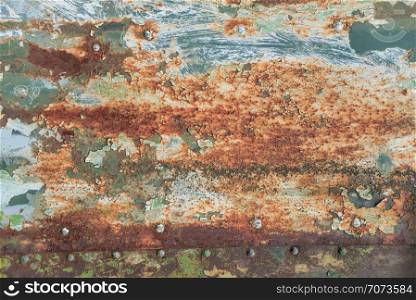 Grunge texture: old rusty metal surface covered with blue paint flaking and cracking texture, with seam and rivets
