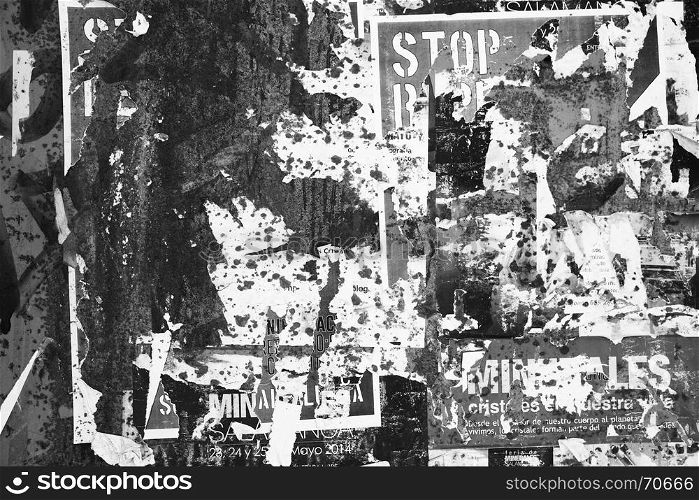Grunge textured background with torn posters. Black and white image