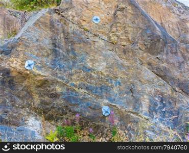 grunge wall stone background or texture solid nature rock with construction steel for netting protection landslide hill