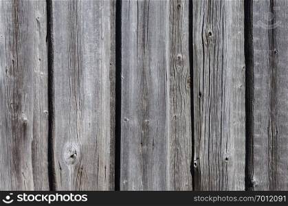 Grunge wooden background. Fragment of an old gray wooden fence.