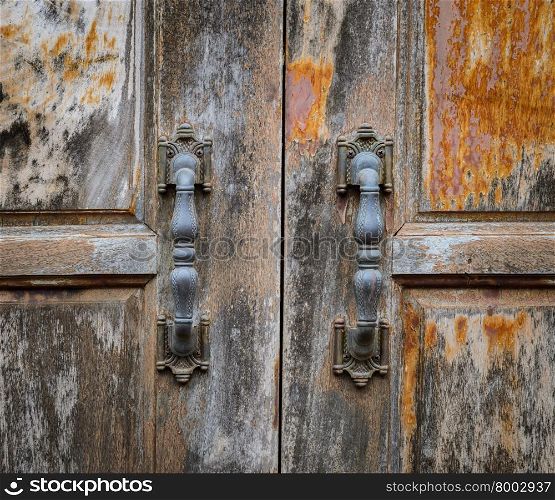 Grunge wooden door with metal handles