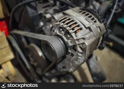Grungy alternator on engine with belt on