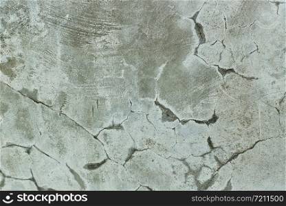 Grungy distressed wall and floor with large cracks.