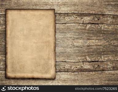 Grungy paper sheet over rustic wooden background. Aged vintage texture
